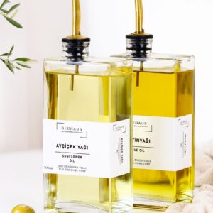Glass bottles of golden cooking oil with pour spouts