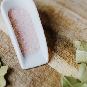 Scoop of fine Himalayan pink salt with bay leaves