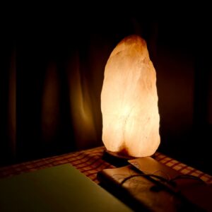 Glowing Himalayan salt lamp on a wooden base